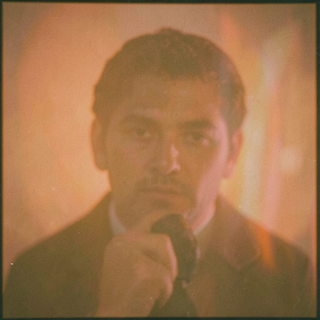 A dim theater lobby at dusk, warm amber light spilling through a doorway, with soft shadows and a moody cinematic atmosphere, rendered with analog film grain.